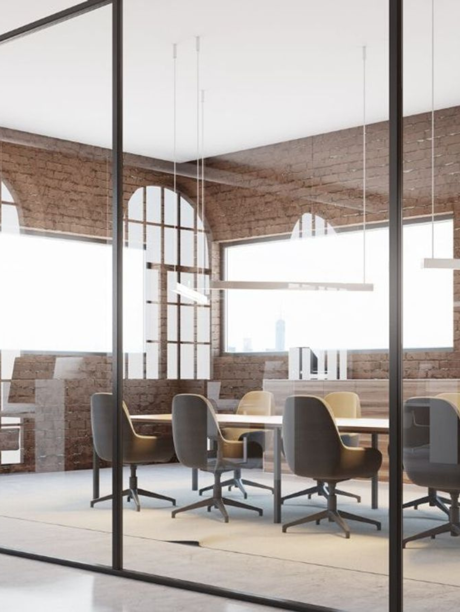 Conference room with glass walls, table, chairs, and brick interior.
