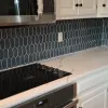 A kitchen with white cabinets , a black stove top oven , and a microwave.