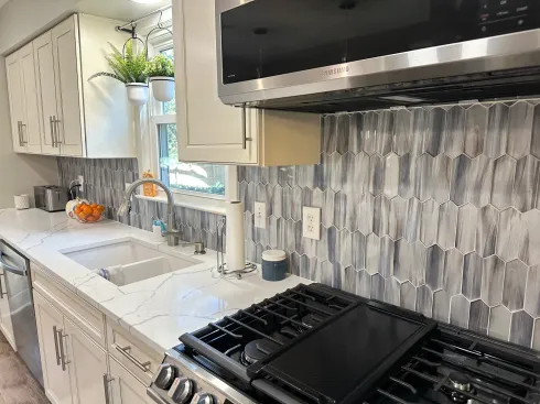 A kitchen with a stove , sink , and microwave.
