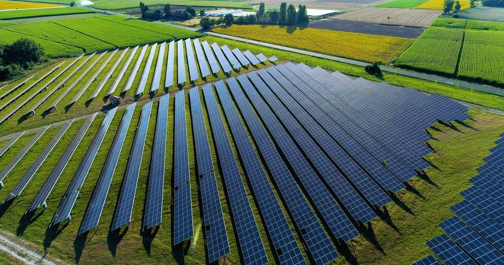 An Aerial View of a Row of Solar Panels in a Field — Electricians in Parkes NSW
