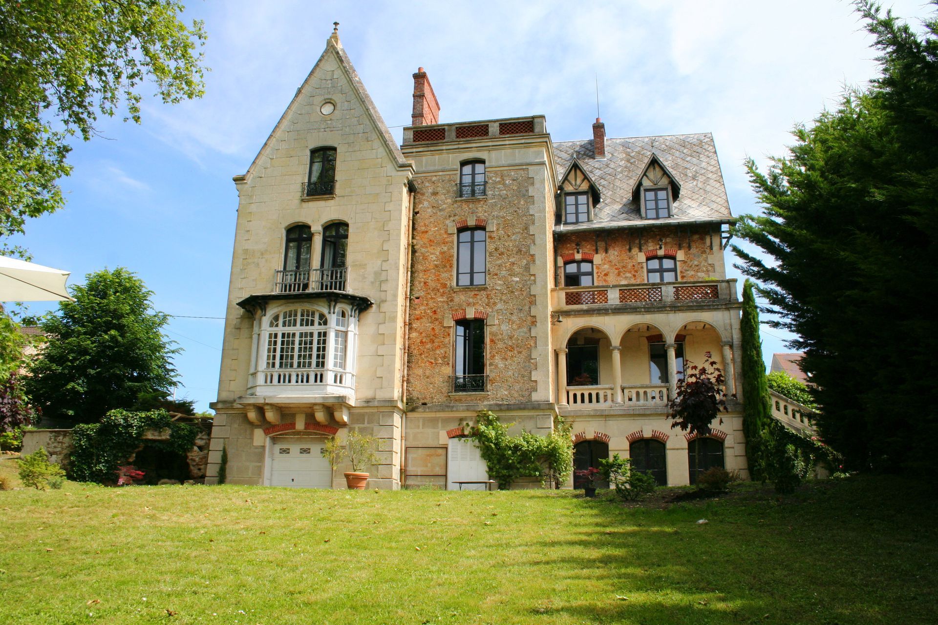 A large house is sitting on top of a lush green hillside