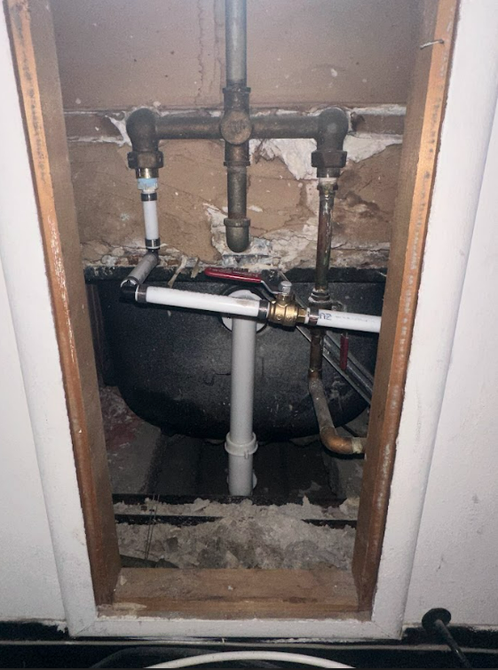 A bathroom sink is being installed in a hole in the wall