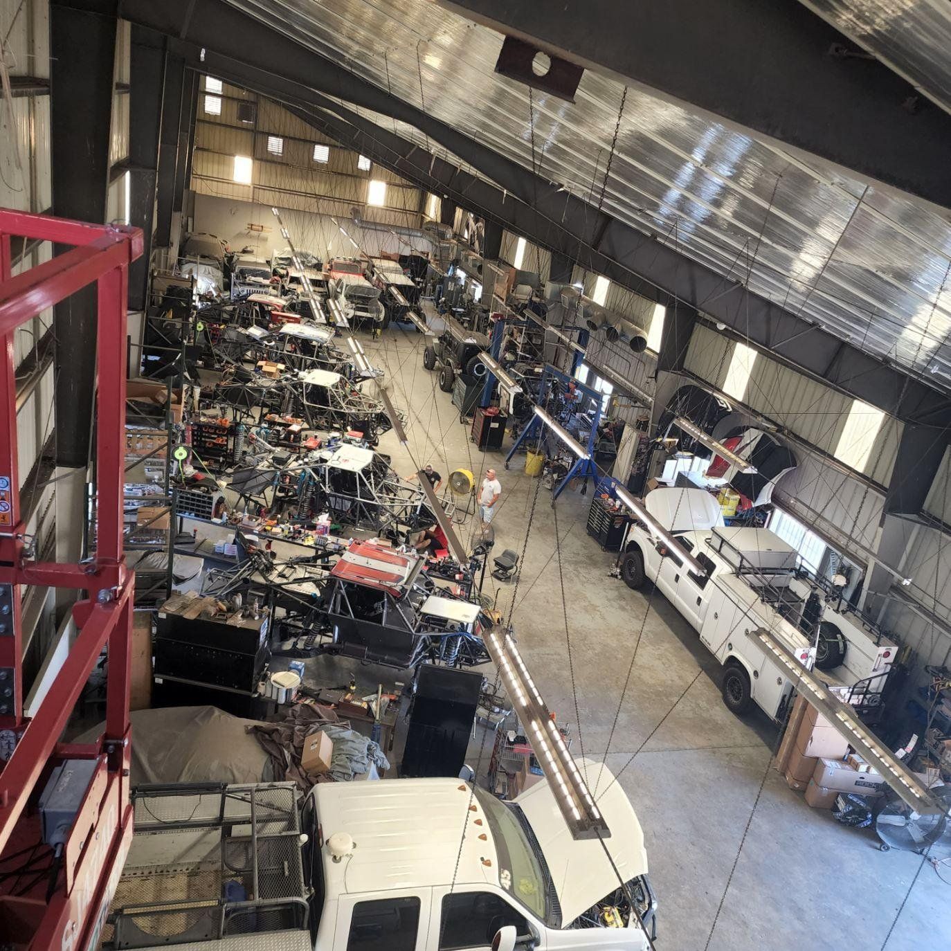 A large warehouse filled with lots of trucks and machinery