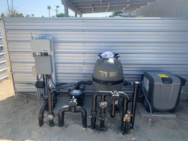 A swimming pool filter is sitting in front of a metal wall