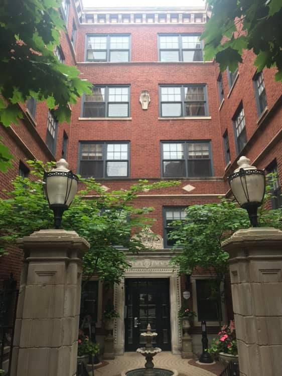 A large brick building with a fountain in front of it