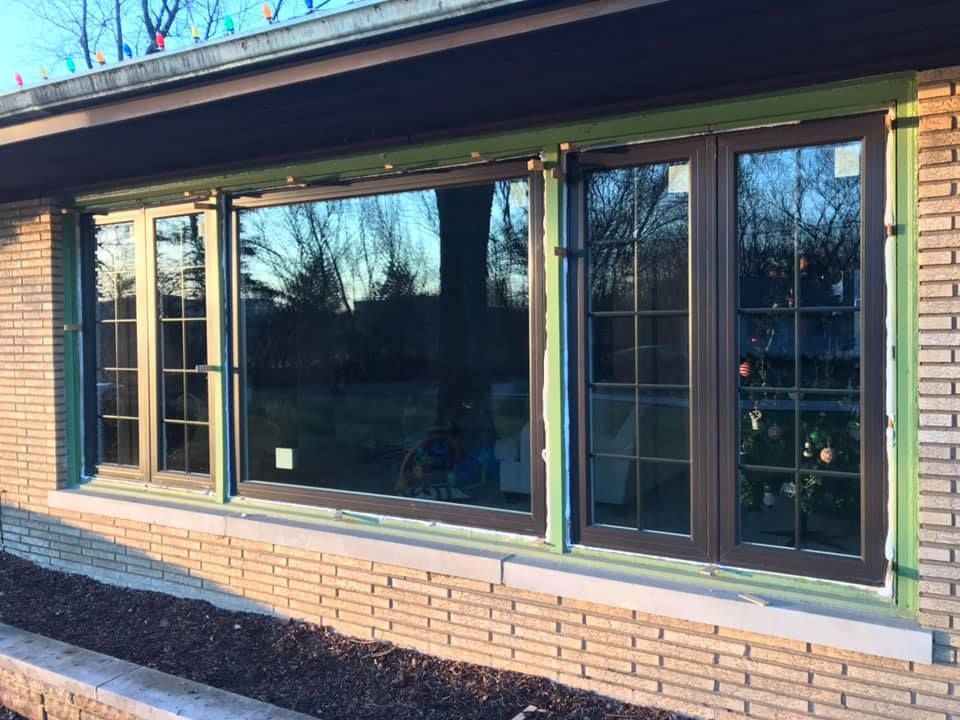 A large window on the side of a brick house.
