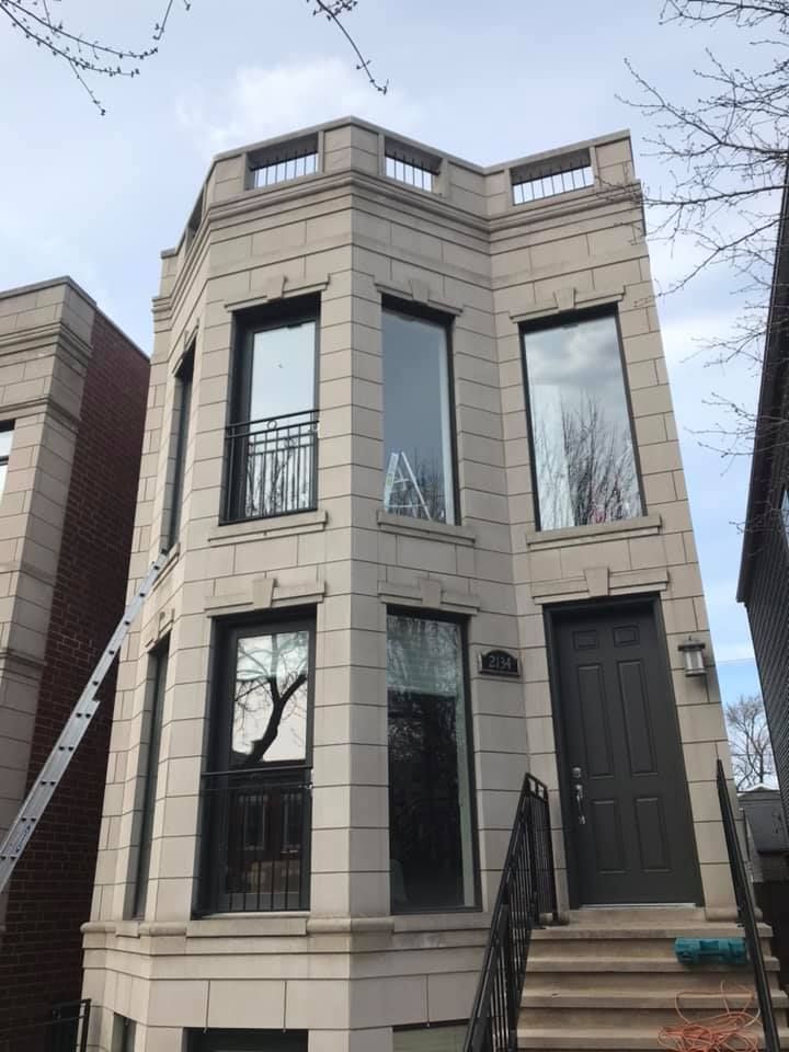 A large brick building with a ladder in front of it.