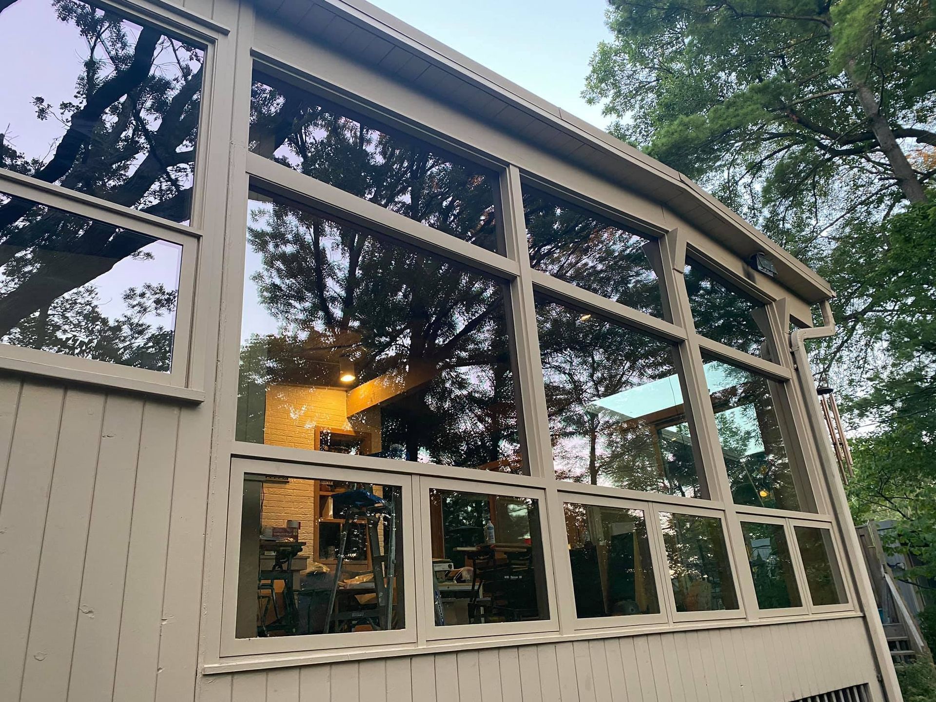 A house with a lot of windows and trees in the background