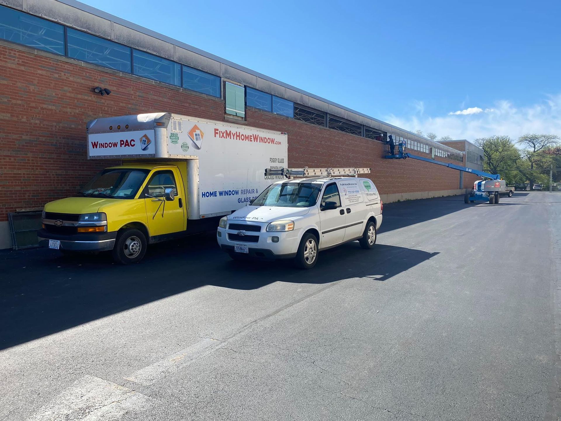 Two trucks are parked on the side of the road in front of a building.