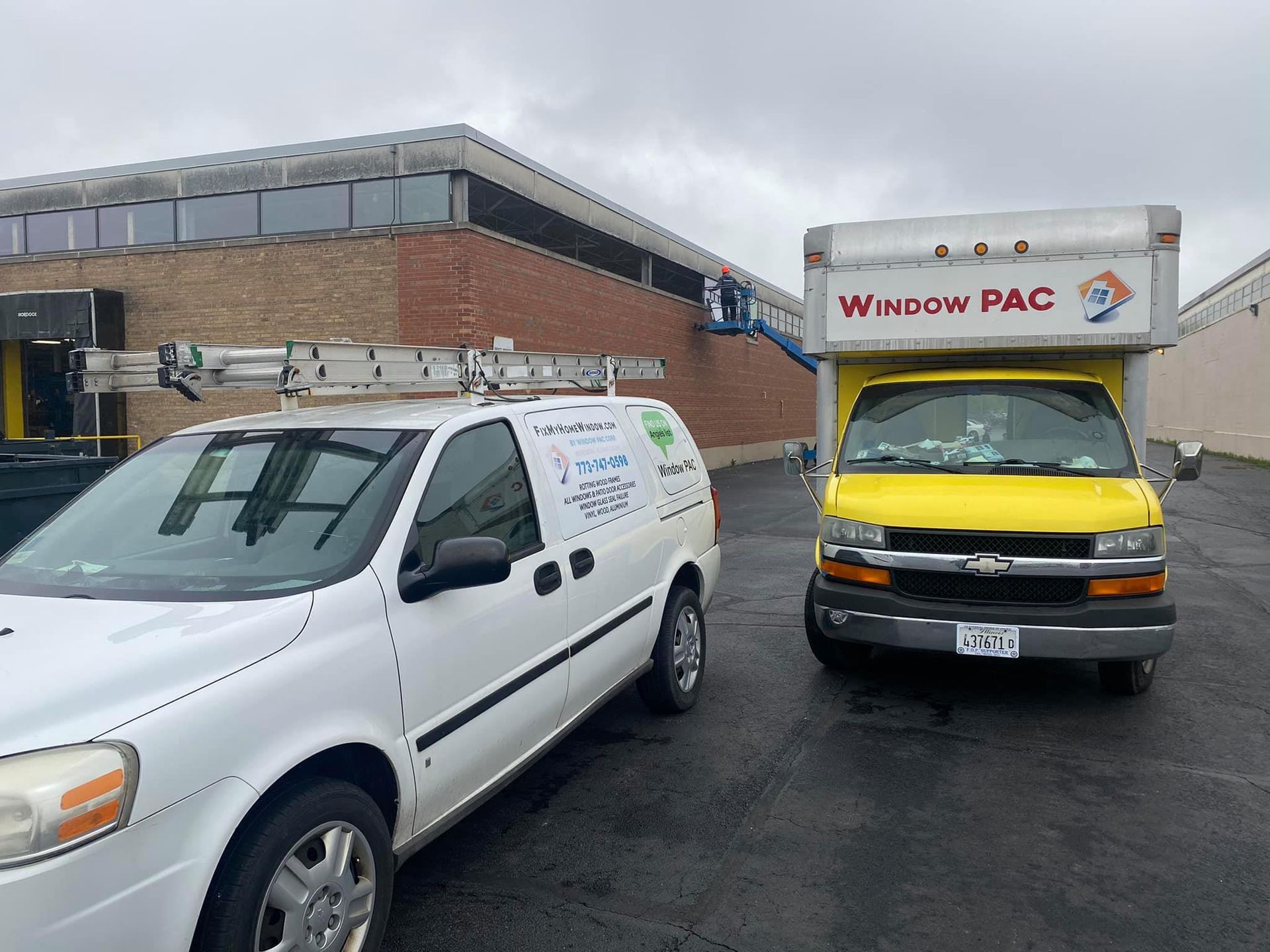 A yellow window pac truck is parked next to a white van