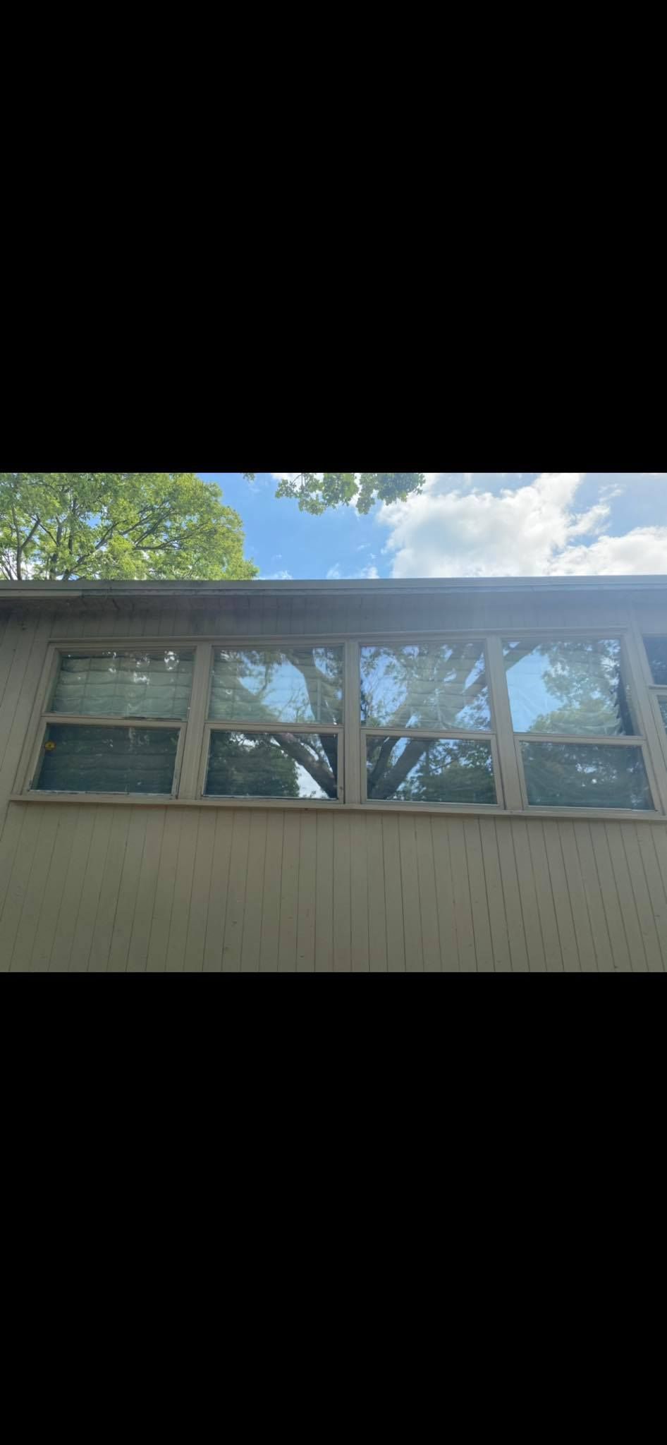A house with a lot of windows and trees in the background.