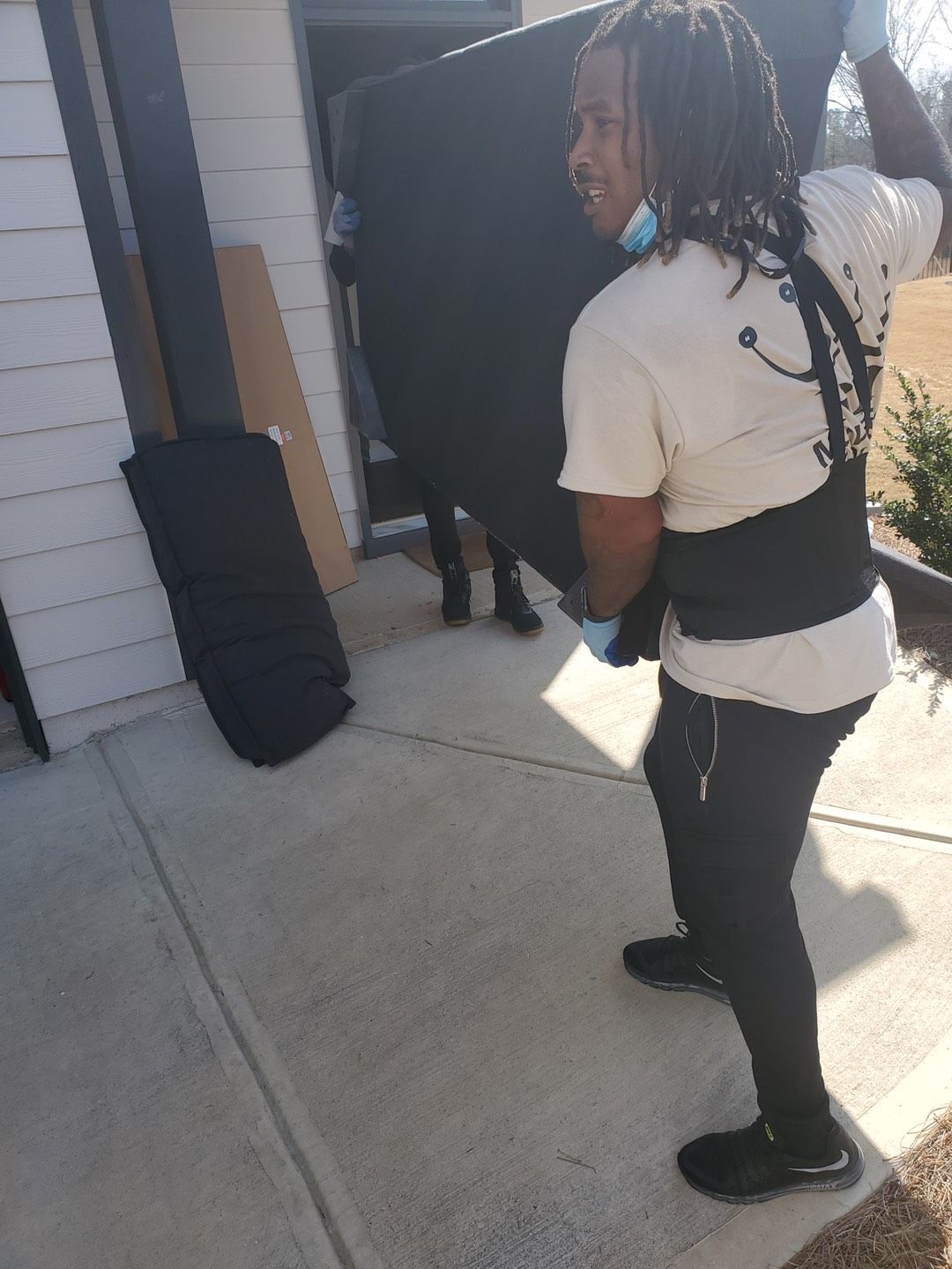 Two Young Male Movers In Uniform Placing Television | Atlanta, GA | Royal Haul Movers