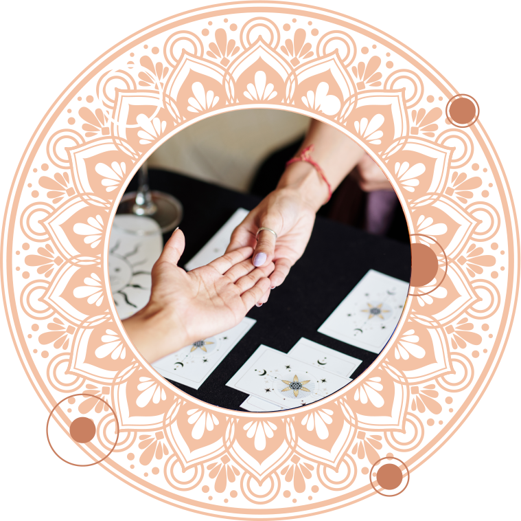 Palm reading with tarot cards in front of a circular, ornate, light-orange design.