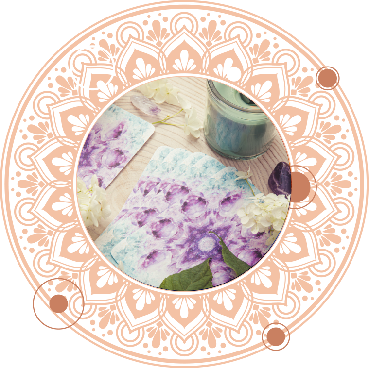 Floral-patterned paper and candle inside an ornate peach-colored mandala, evoking a sense of calm.