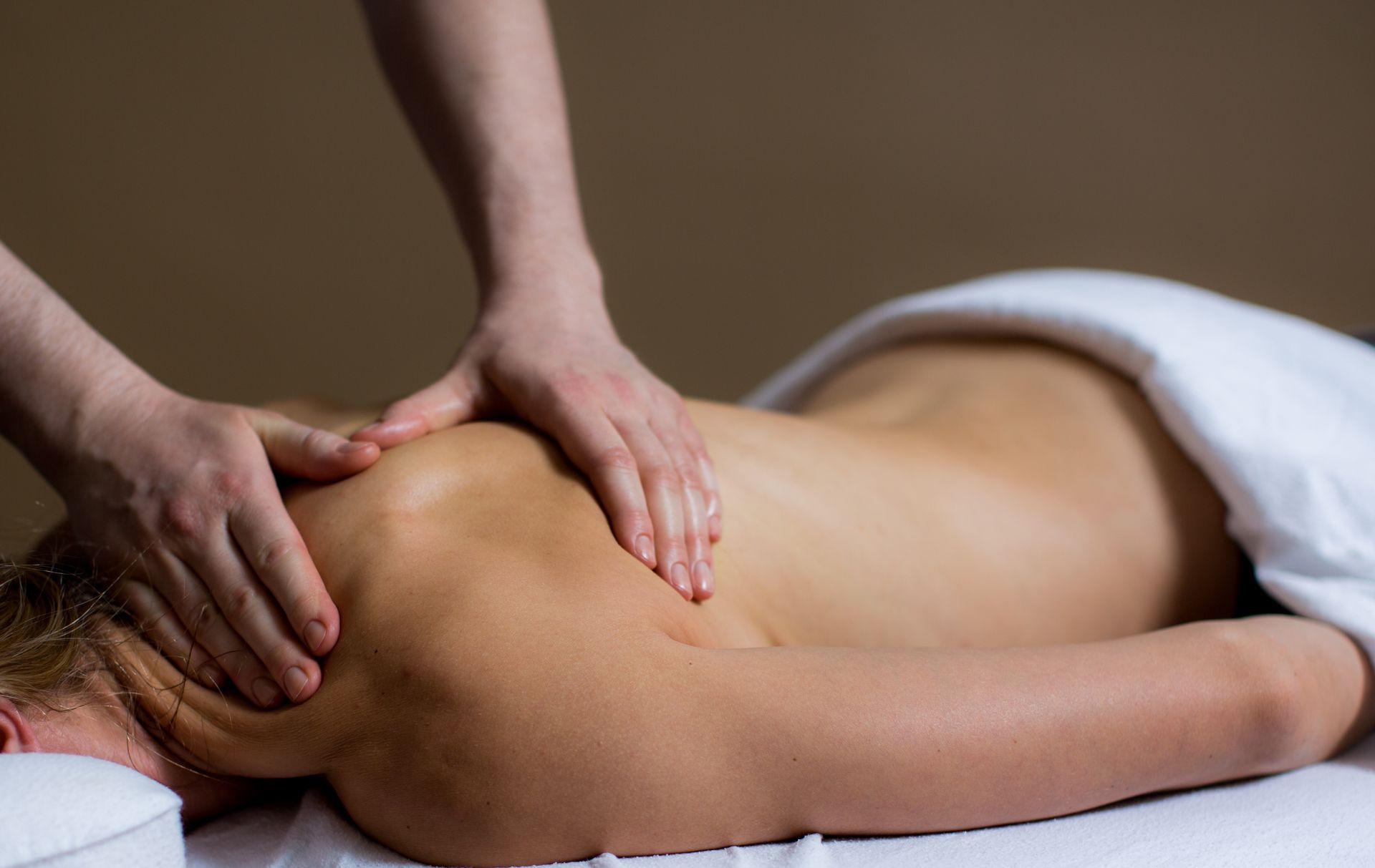 a woman is getting a sports massage at A Touch of Recovery in Plymouth, MI