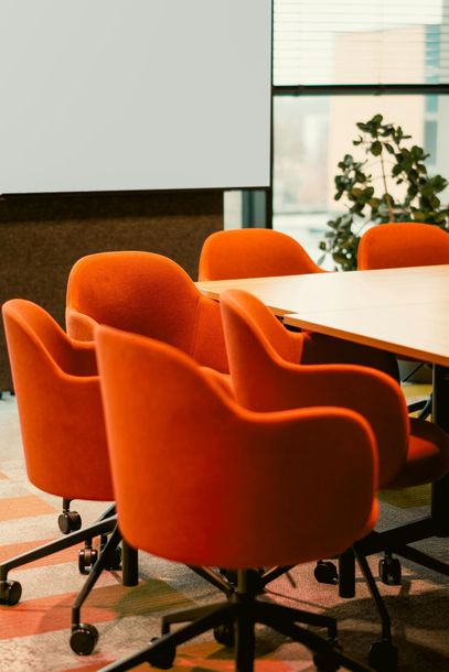 Orange office chairs around a conference table in a modern meeting room