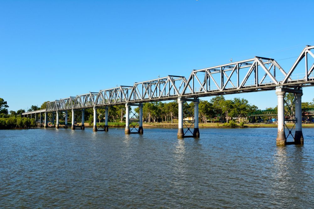 A Bridge Over A Body Of Water With Trees In The Background  — Armstrong Removals in Bundaberg, QLD