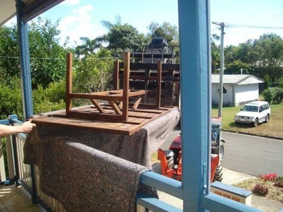 Two chairs are sitting on top of a table on a porch — Armstrong Removals in Ninderry, QLD