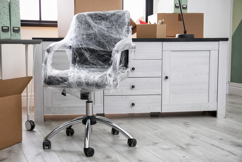 An Office Chair Is Wrapped In Plastic Wrap In A Moving Office — Armstrong Removals in Gympie, QLD