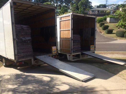 Two Moving Trucks Are Parked Next to Each Other in A Driveway — Armstrong Removals in Ninderry, QLD