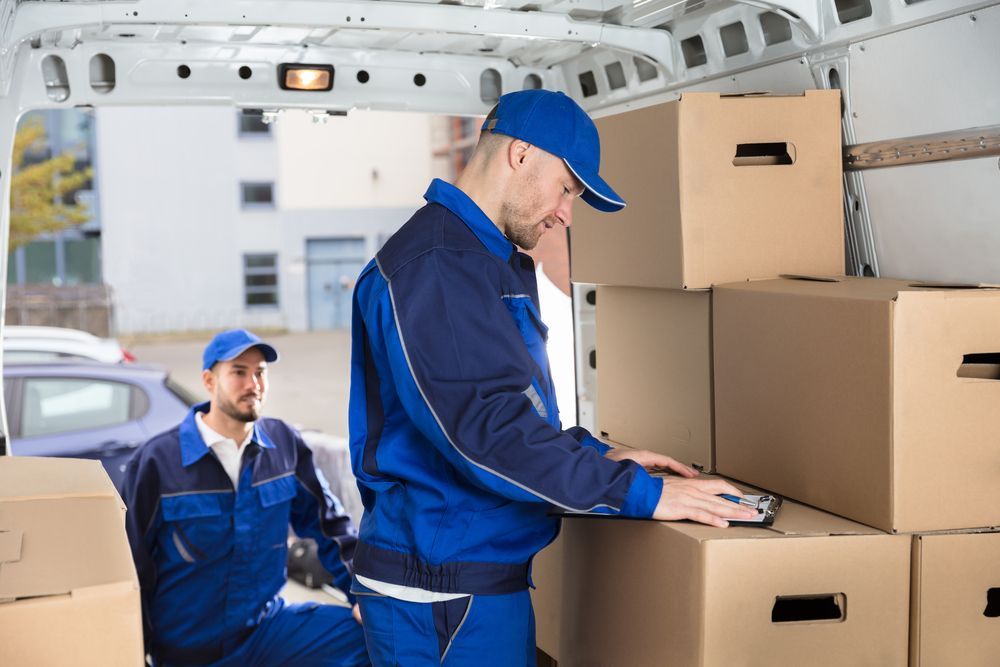 Two Men Are Loading Boxes Into A Van — Armstrong Removals in Mackay, QLD