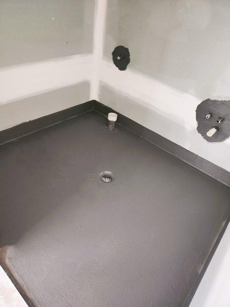 A Black Shower Tray is Sitting in a Bathroom Next to a Bathtub — Legend Waterproofing In Nords Wharf, NSW