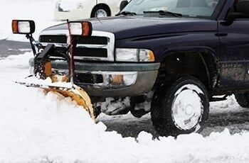 Truck with plow removing snow