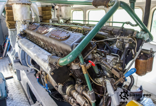 A man is working on a diesel engine in a garage at diesel repair denver.