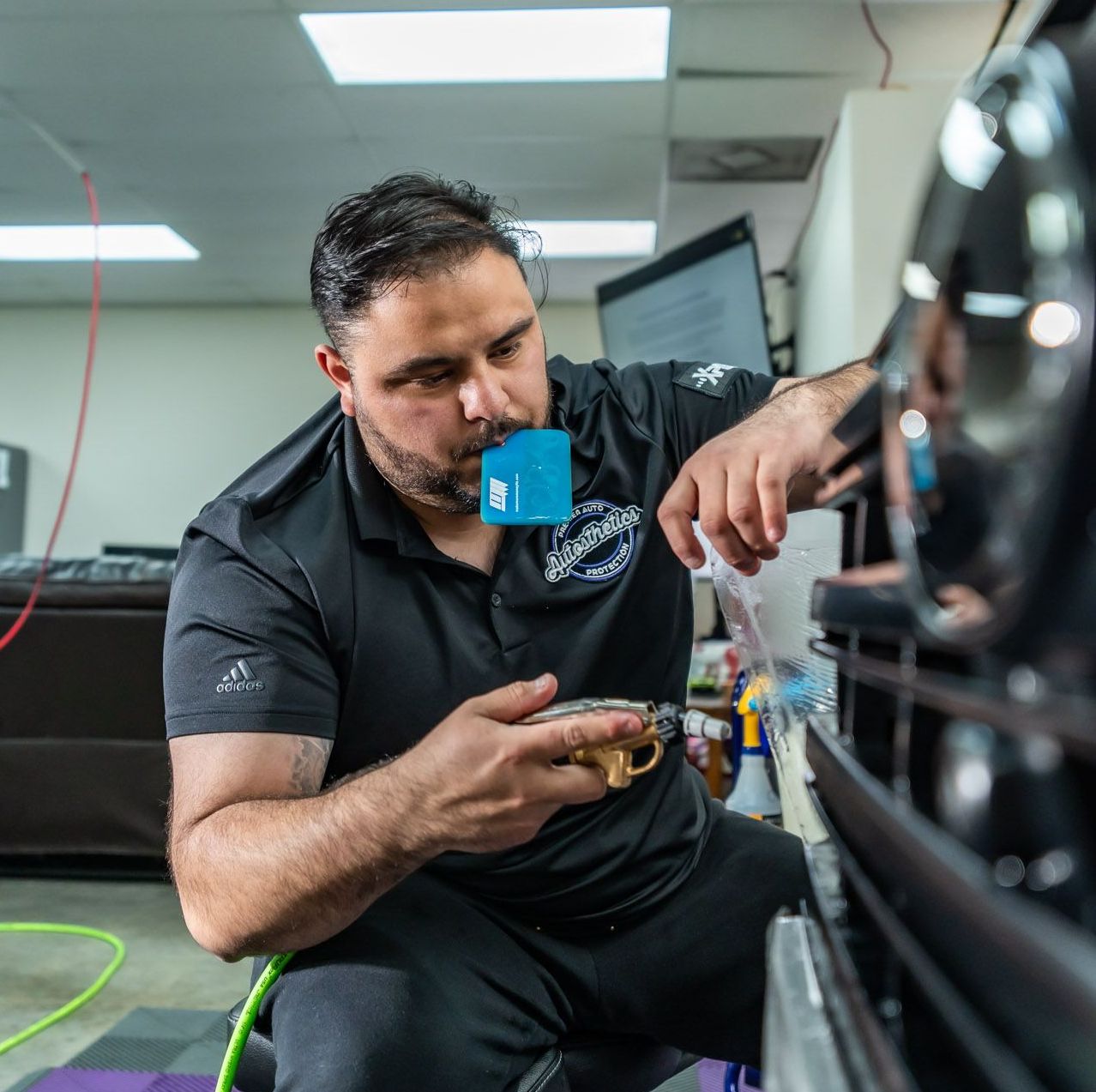 A man in a black shirt is working on a car