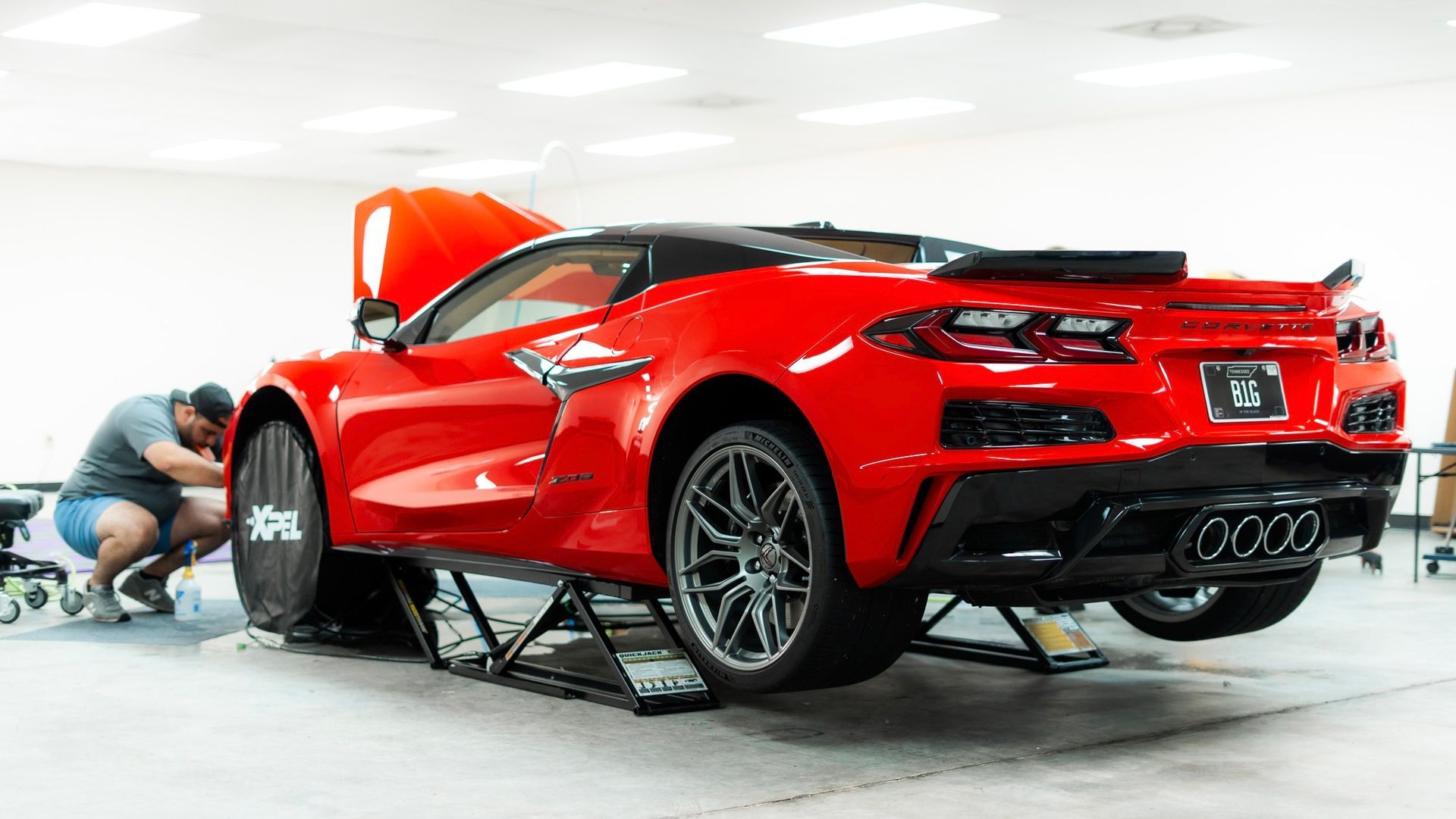 A white suv is parked in a field with a cloudy sky in the background.