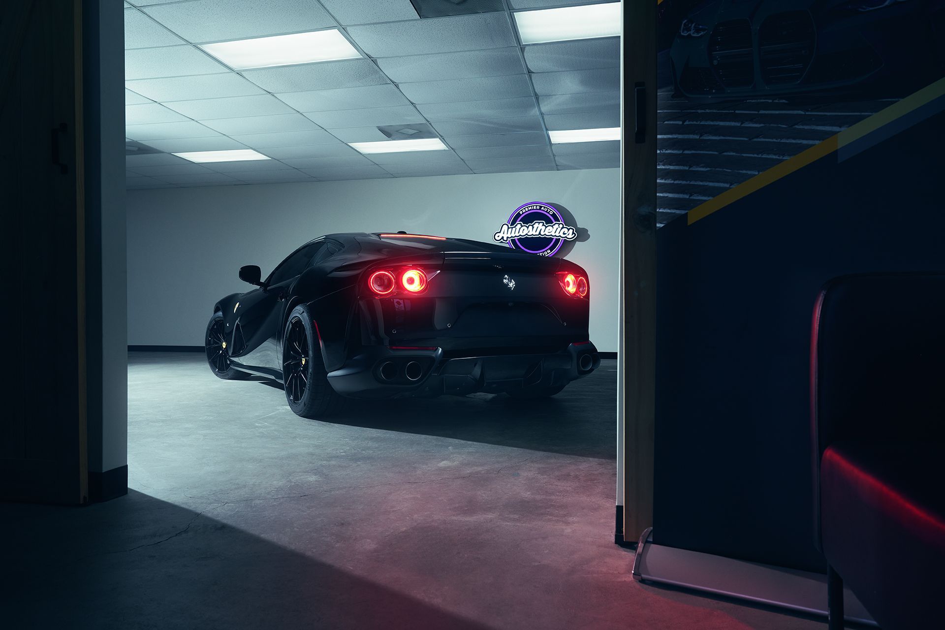 Black sports car in a garage with a crystal ball on the car.