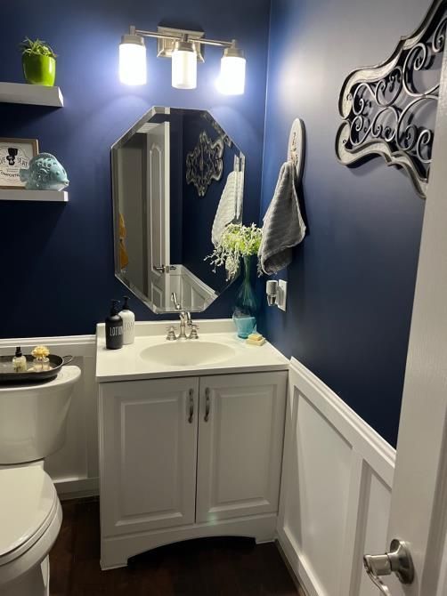 A bathroom with a toilet a sink and a mirror