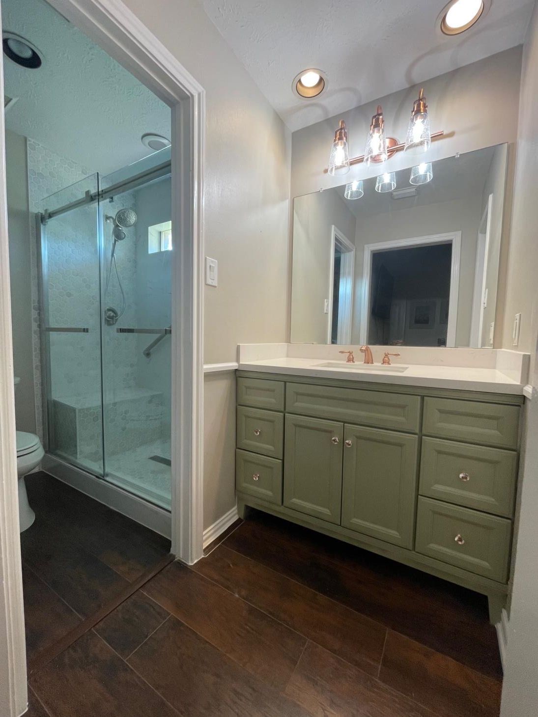 A bathroom with a sink , toilet and shower.