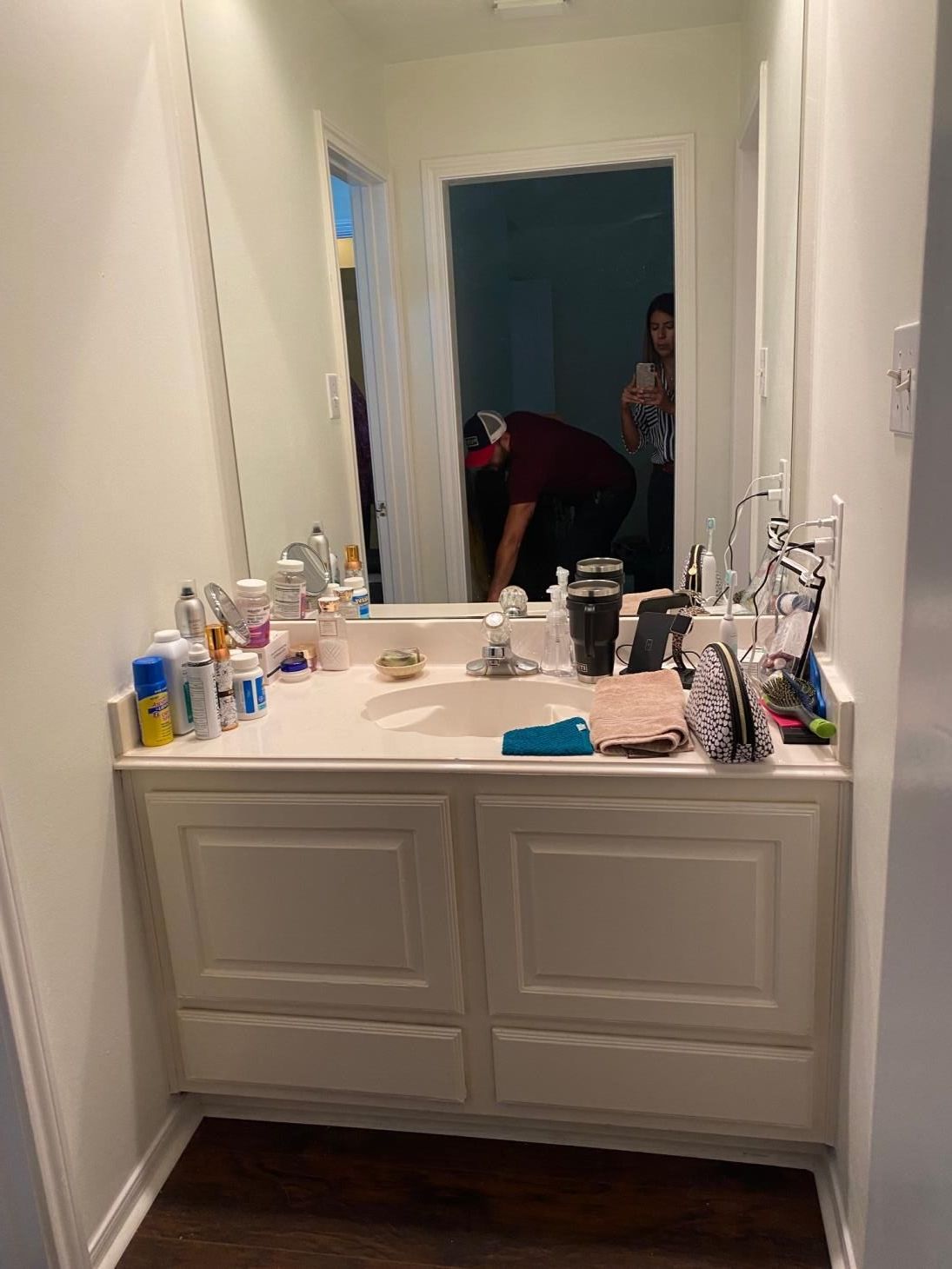 A bathroom with a sink , mirror and cabinets.