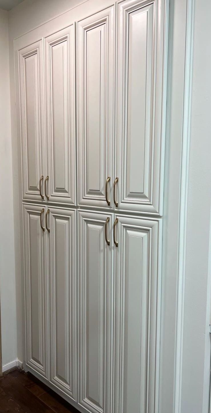 A bunch of white cabinets are sitting next to each other in a room.