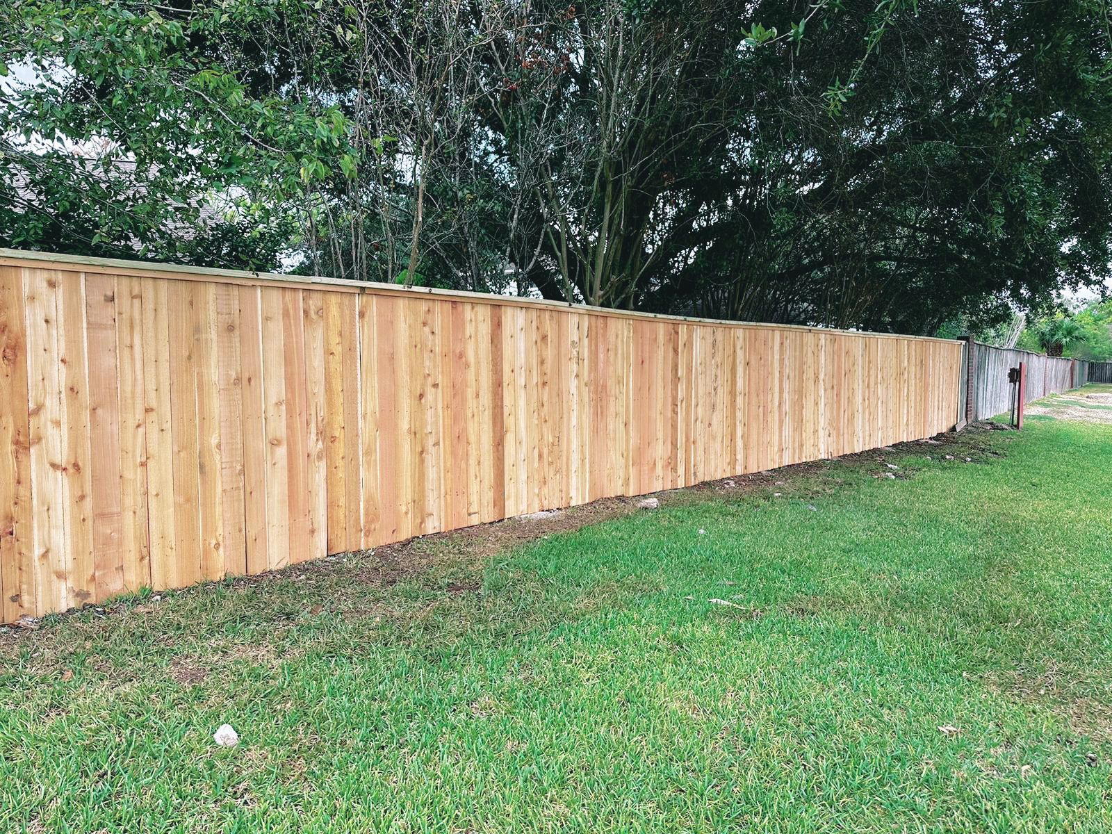 A wooden fence is sitting in the middle of a lush green field.