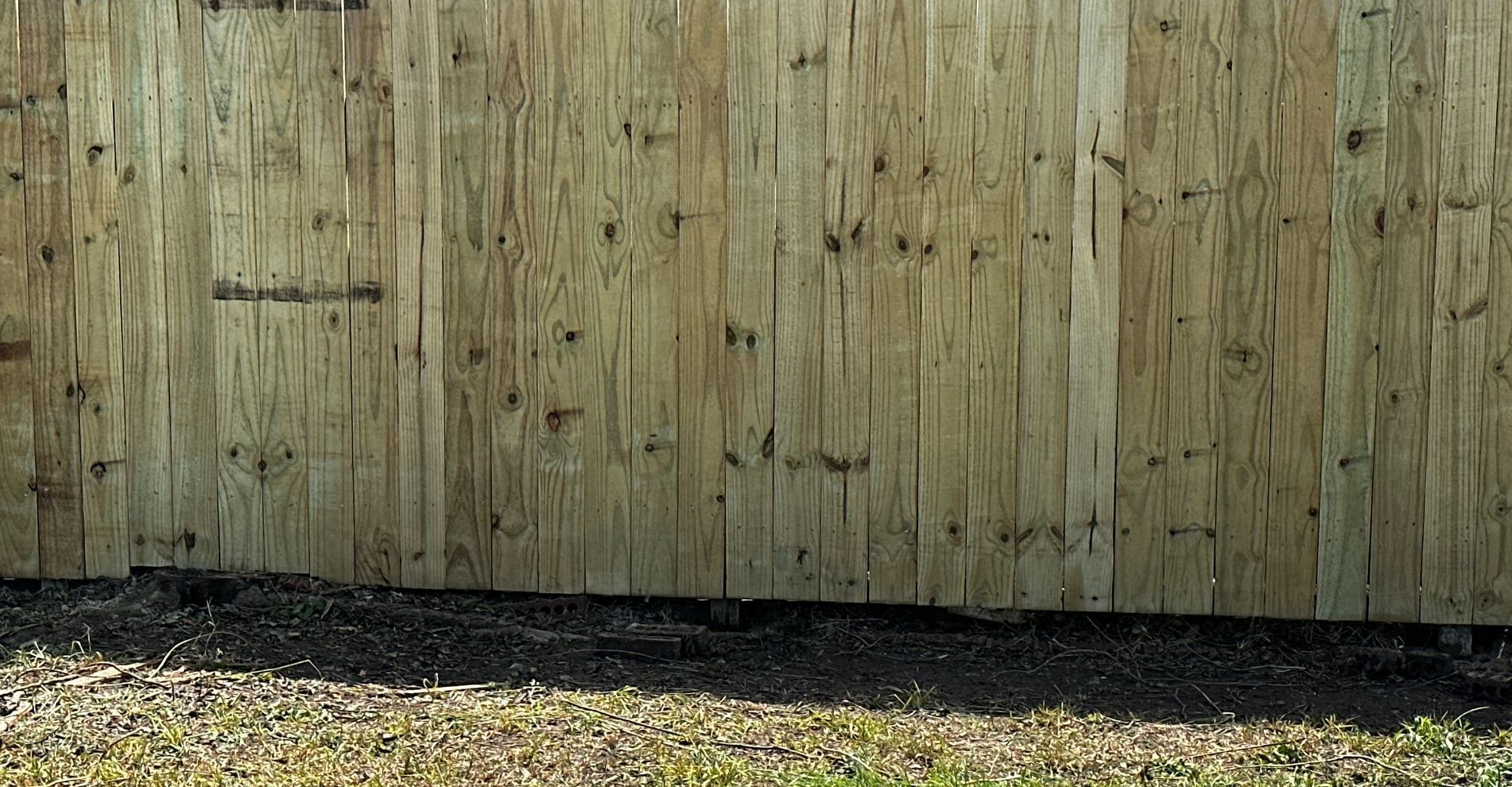 A wooden fence is sitting in the middle of a yard.
