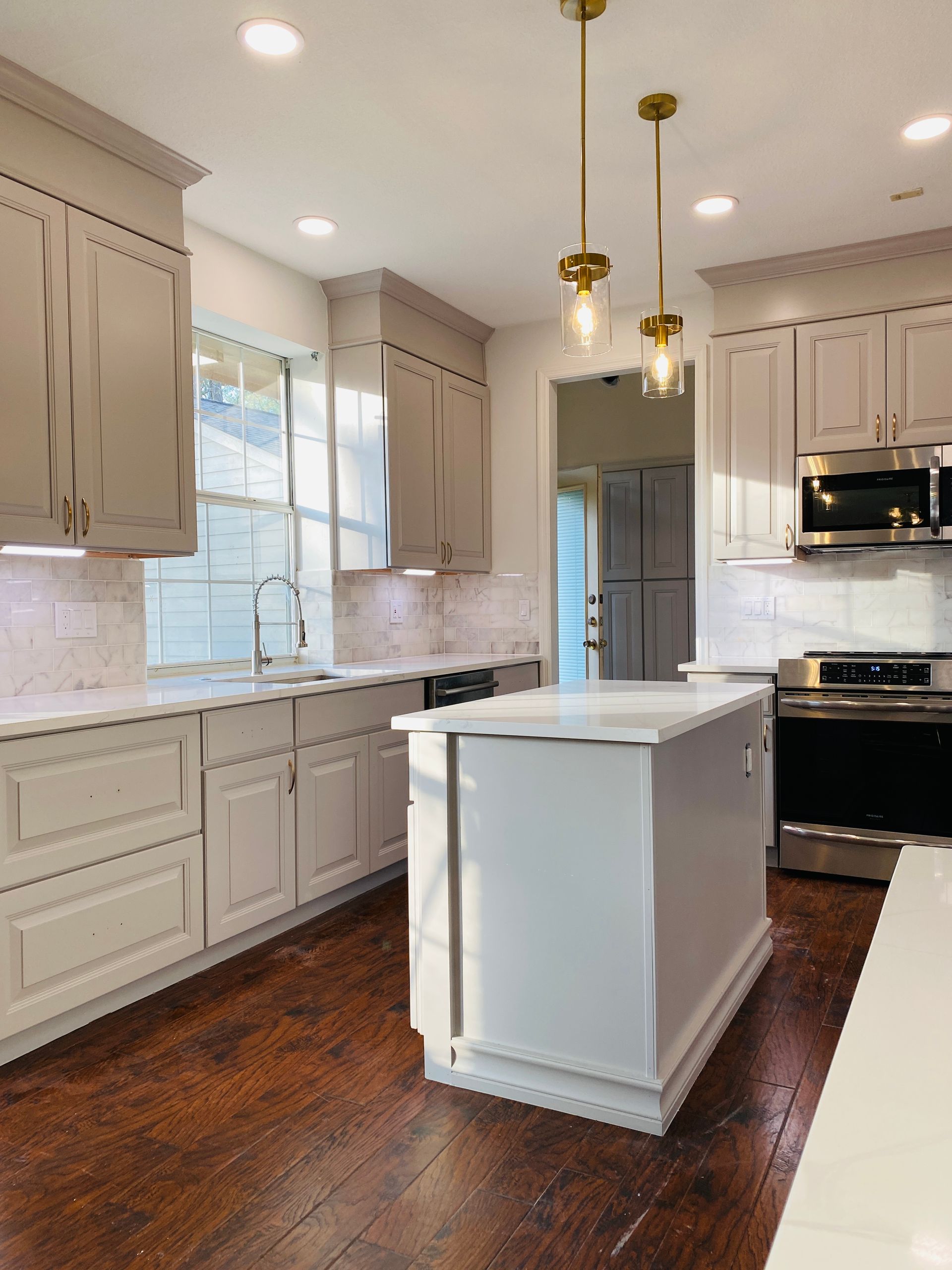 A kitchen with white cabinets and stainless steel appliances