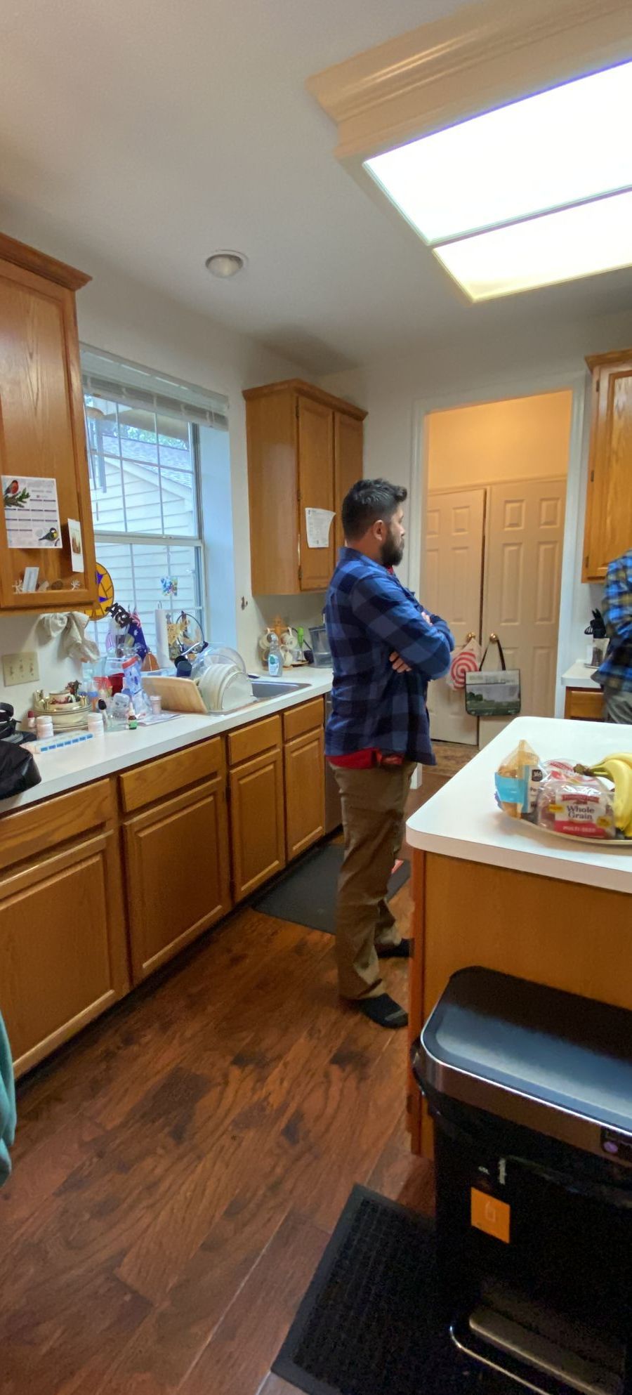 A man is standing in a kitchen with his arms crossed.