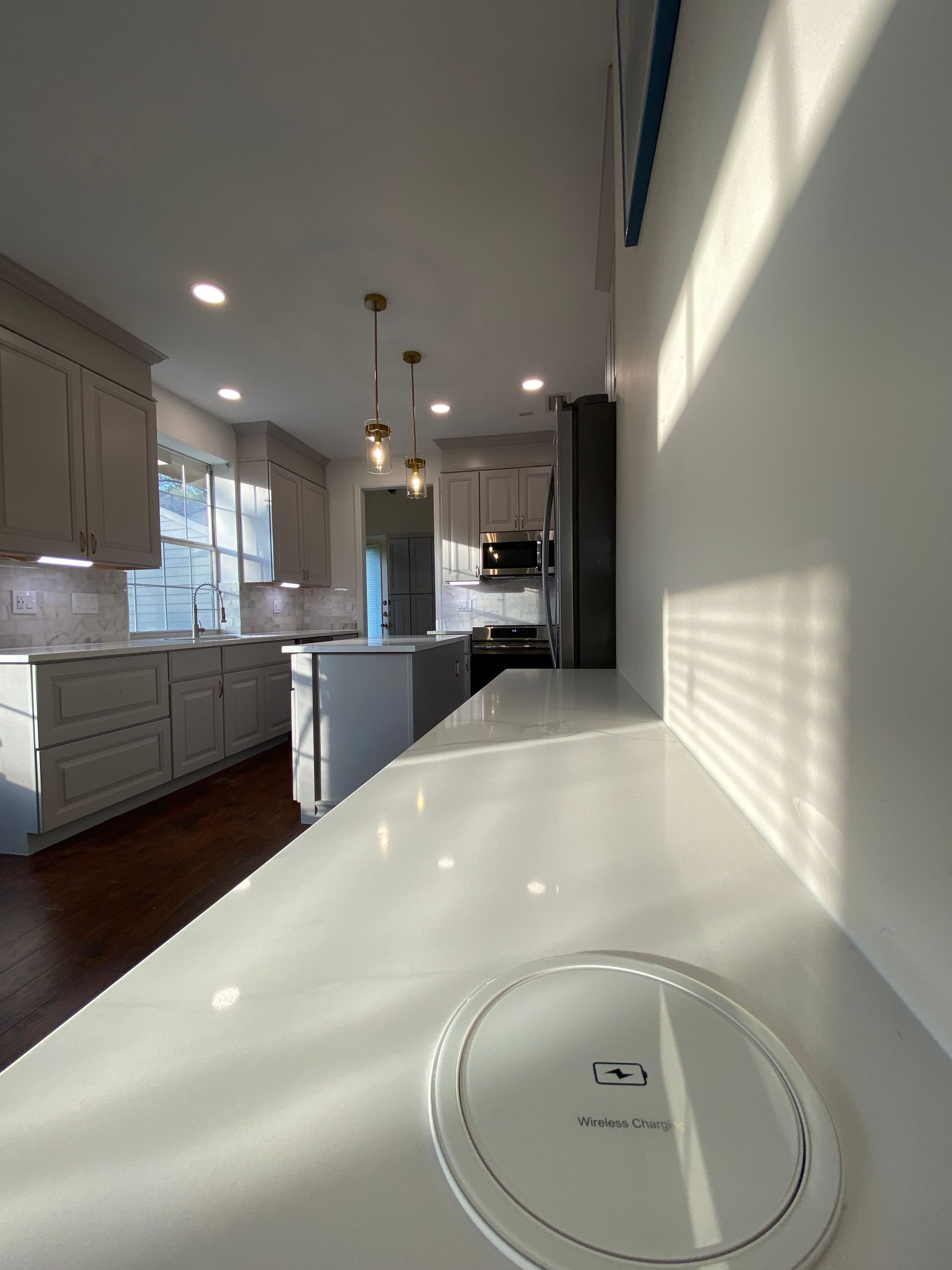 A white counter top in a kitchen with a charger on it