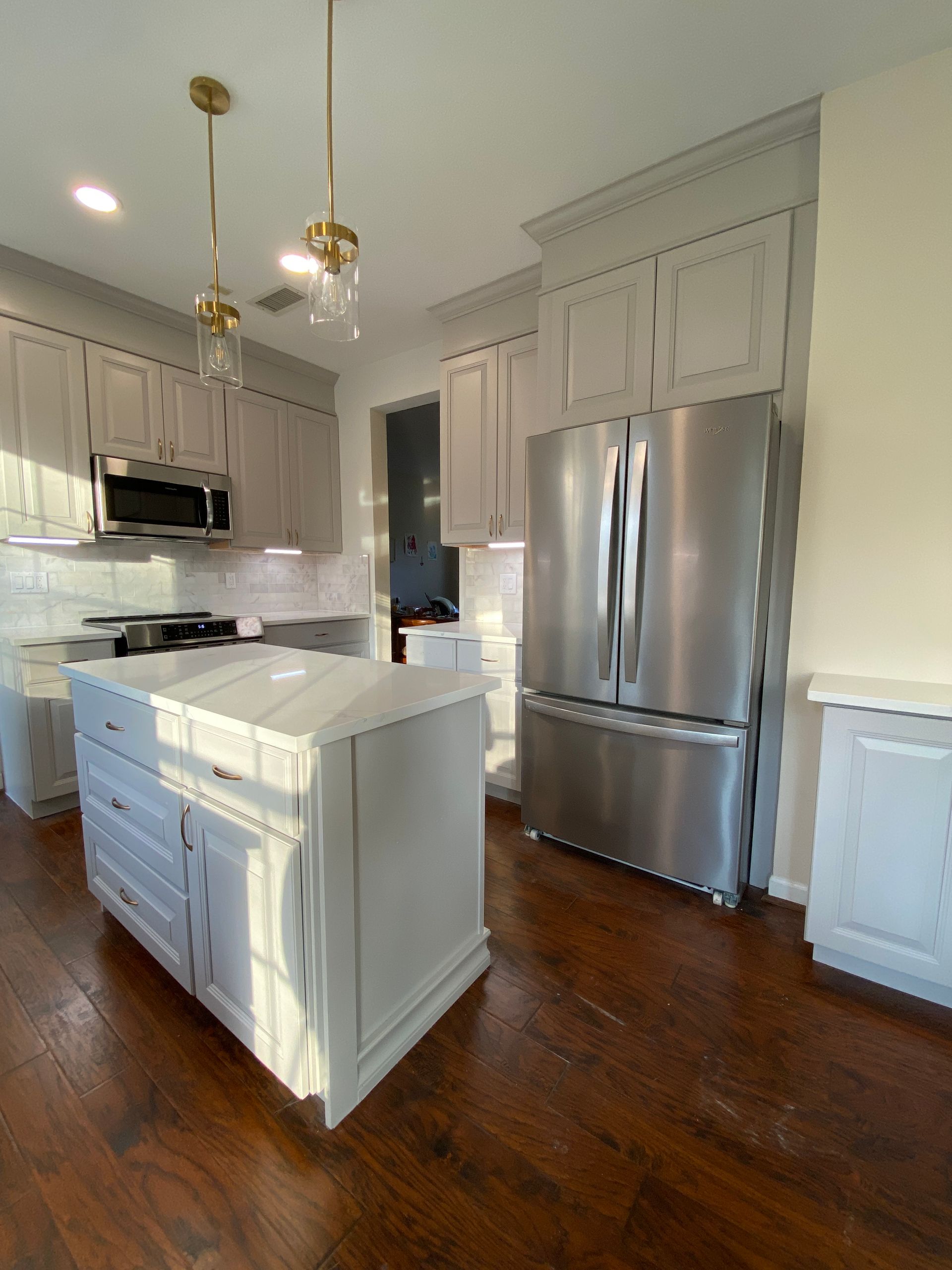 A kitchen with stainless steel appliances and white cabinets.