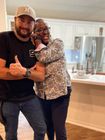 A man and a woman are posing for a picture in a kitchen.