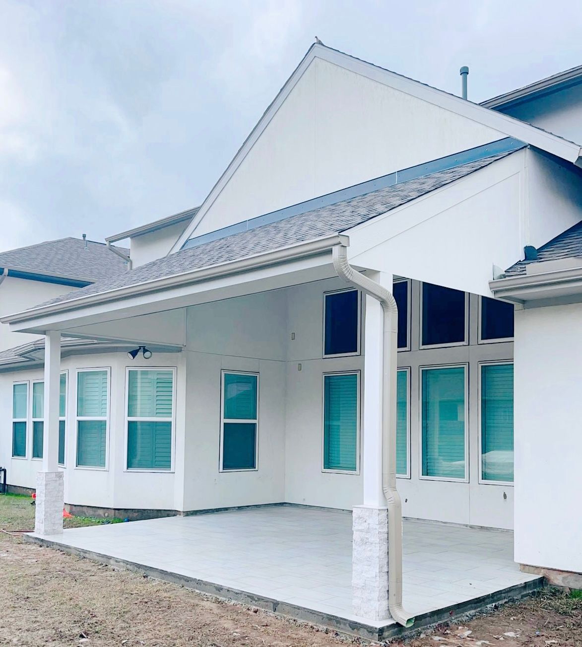 A white house with a covered porch and many windows