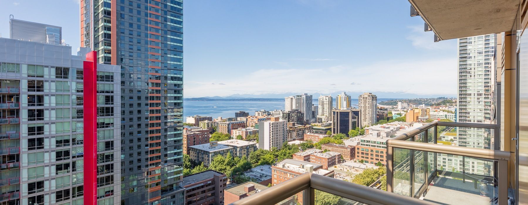 Balcony view from a high-rise apartment overlooking downtown and the water.
