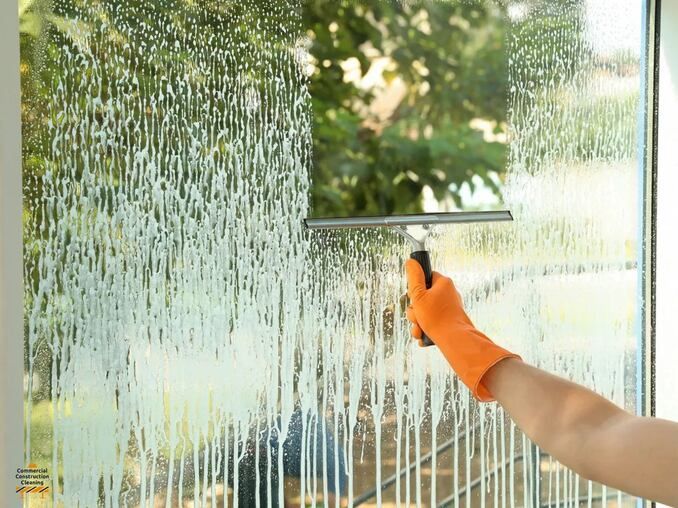 A person cleaning a window using a wiper
