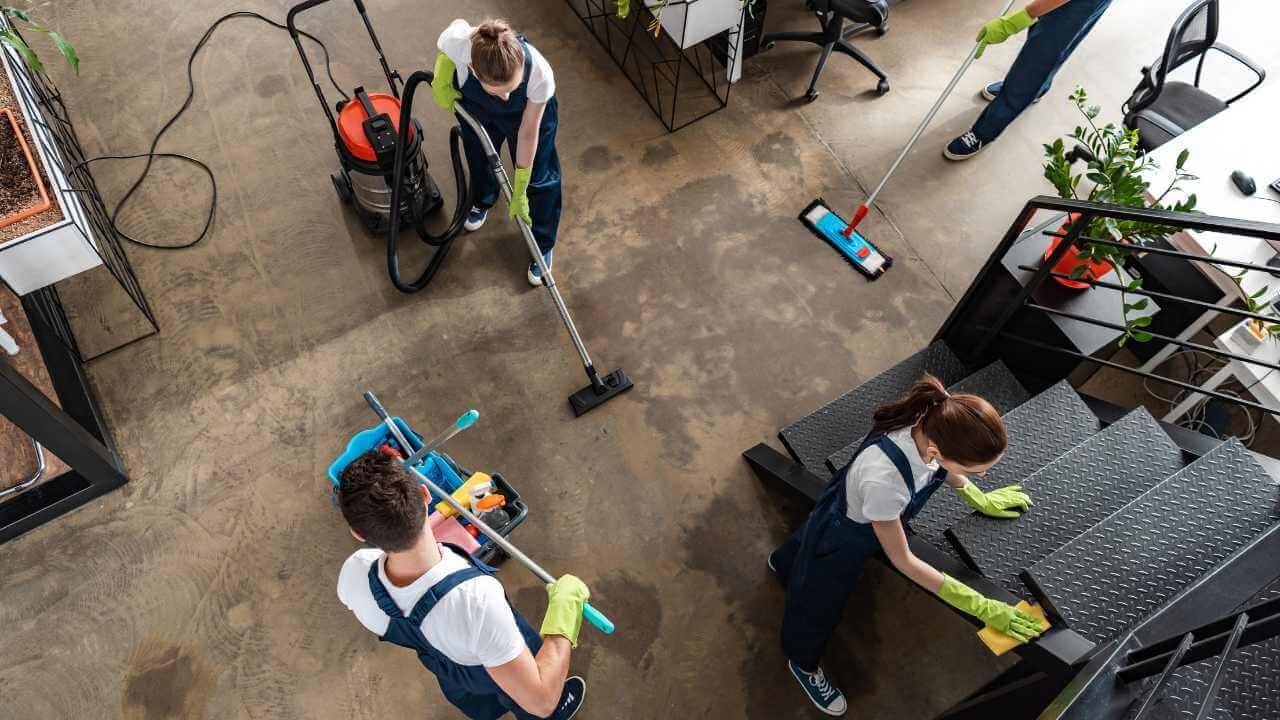 A group of cleaners are cleaning the floor of an office.