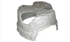 A gray, molded fiber egg carton cup with a torn side, isolated against a white background.