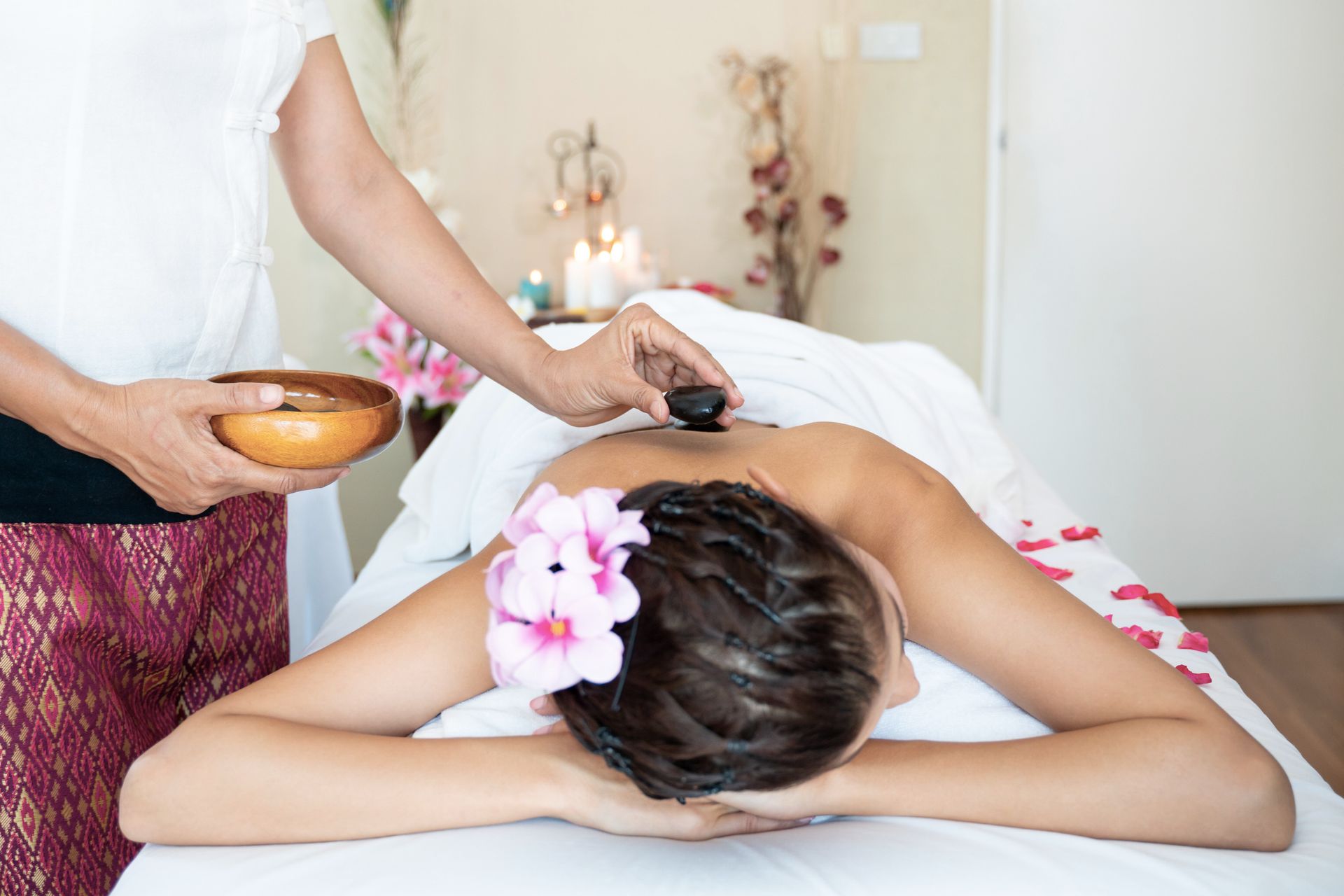 A Woman Is Getting A Massage At A Spa With A Flower In Her Hair — Wilmington, NC — Mystic Massage