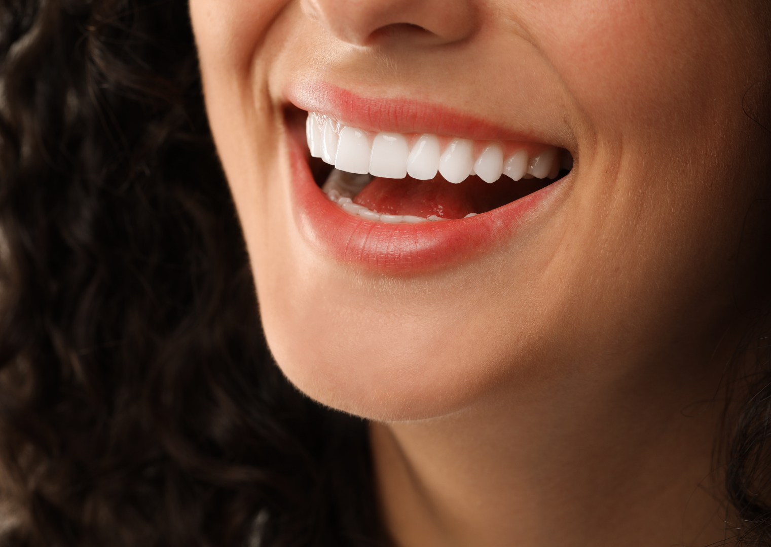Smiling mouth, showing white teeth and pink gums.