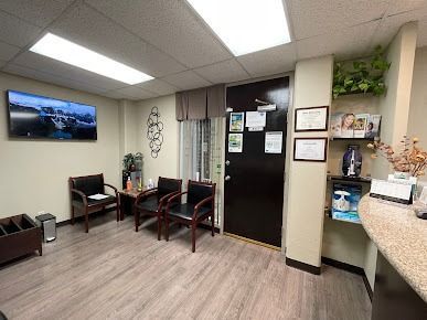 Office reception area with white countertops, shelving, printer, and a beach-themed artwork.